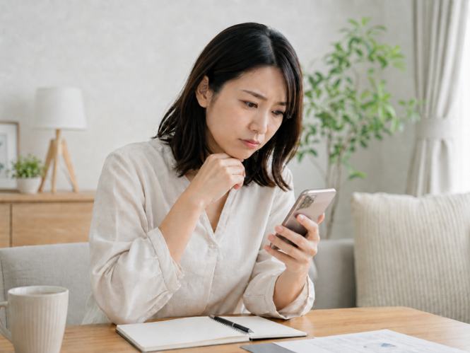 頭皮アートメイクの症例写真をスマートフォンで確認する女性
